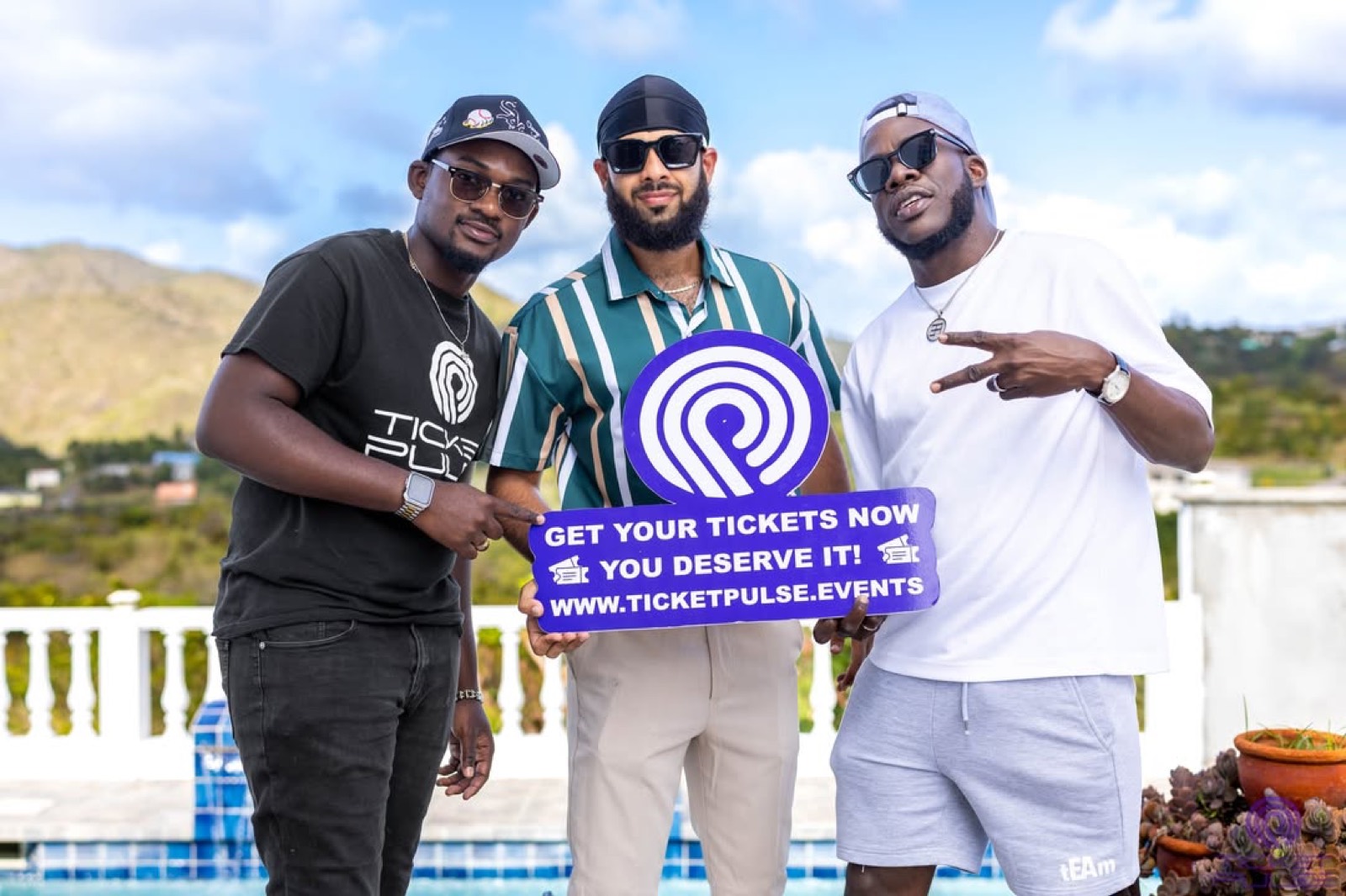 Three of the team holding a TicketPulse board reading Get your tickets now.