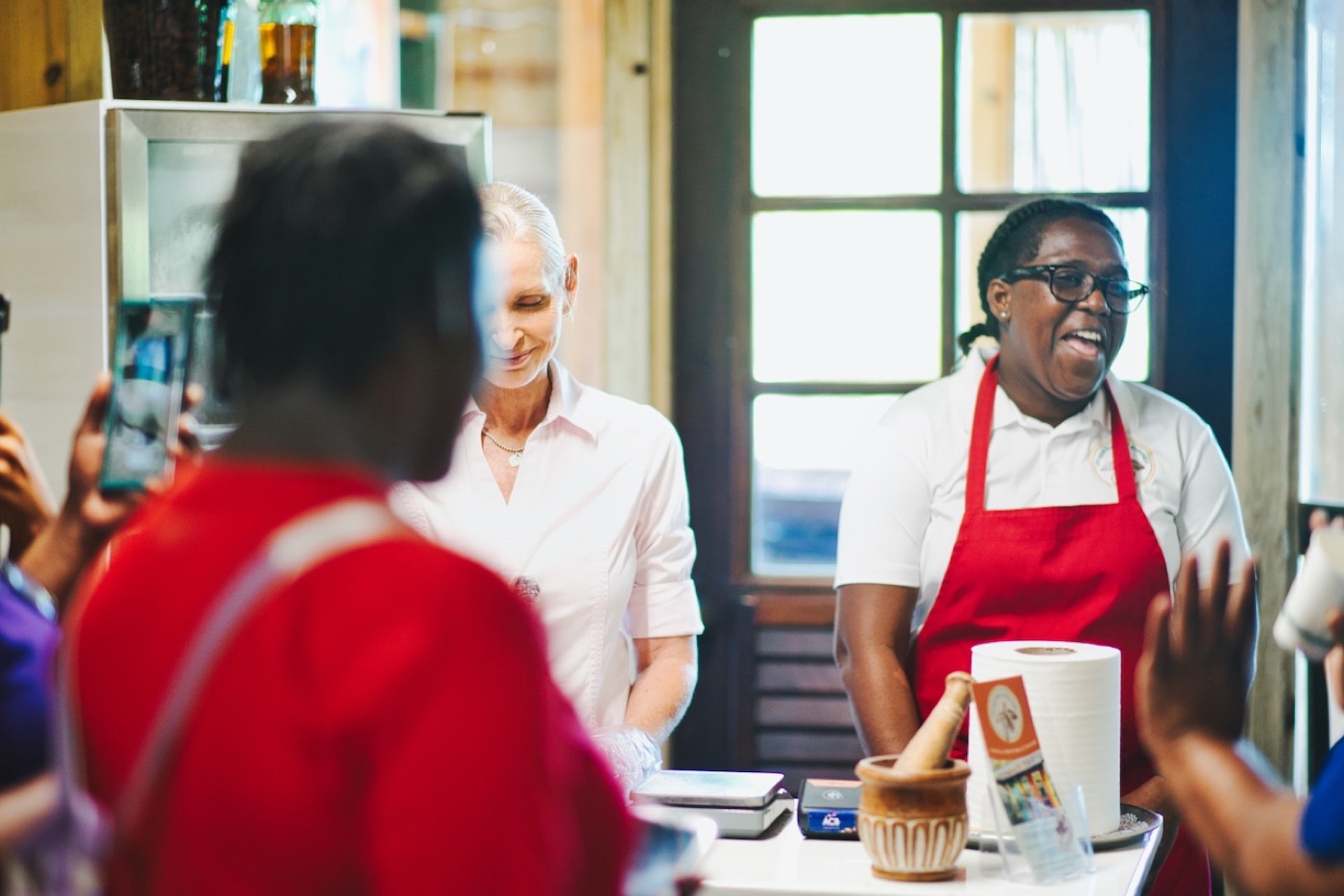 A cocoa-shop demonstration in progress, guests watching and filming.